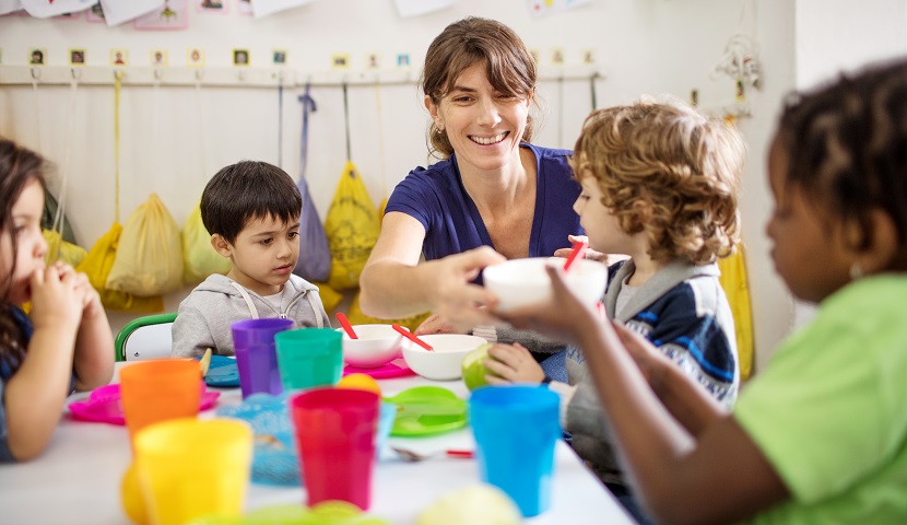 Image of early childhood educator having lunch with children