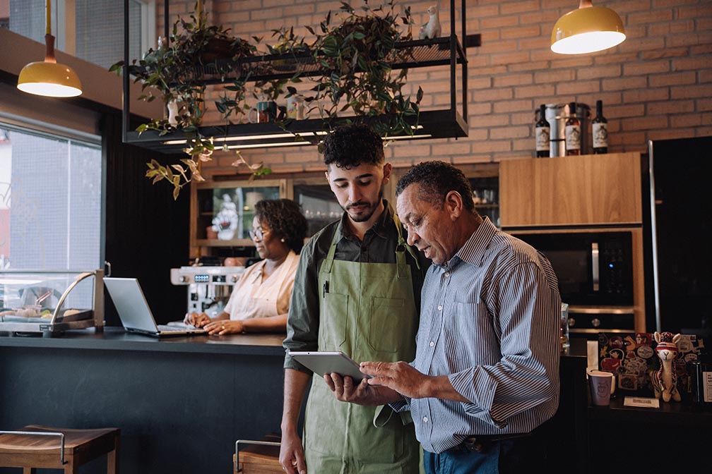 Coffee shop owner talking to employee.