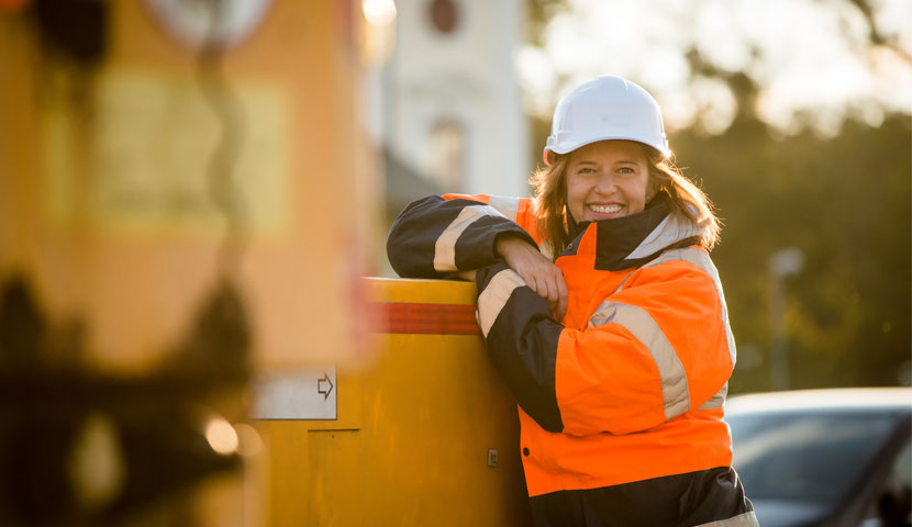 A worker in high vis and a helmet on a worksite.