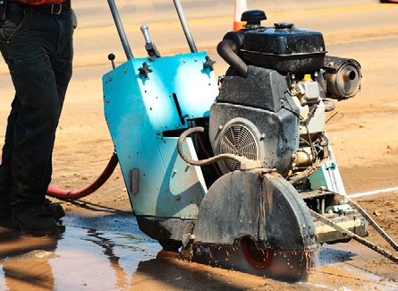 Person pushing a machine that is cutting stone