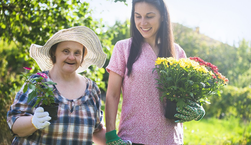 Image of disability sector worker and female gardening