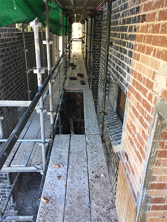 A scaffolding floor showing a missing panel that people could fall through