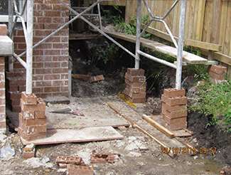 Scaffolding supported by a stack of bricks