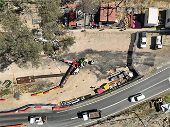 Overturned articulated crane pictured from above. 