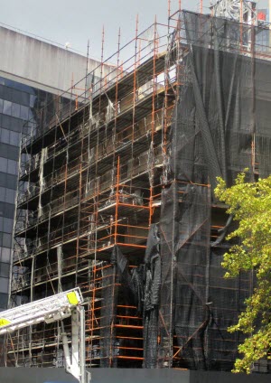 Fire damaged containment netting on a high rise construction at Circular Quay Sydney NSW