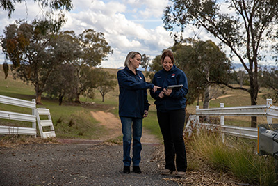 Two SafeWork NSW Inspectors at the entry to a rural property.