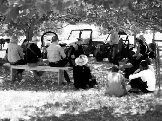 A group of farmers having a discussion under a large shady tree