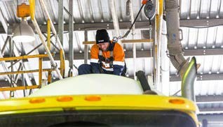 Photo of worker using a fall arrest system on top of a truck