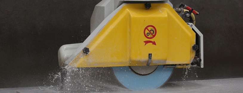 Image of a yellow saw cutting stone.