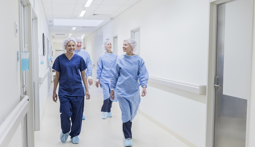 Image of hospital workers walking while wearing blue scrubs