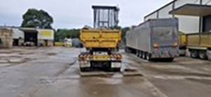 back view of a yellow skip-bin truck at what appears to be at a truck depot, the location where the accident occurred.