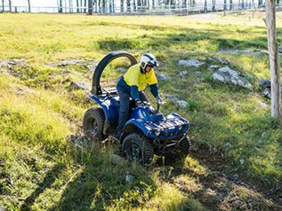 Person on blue quad bike riding down an embankment