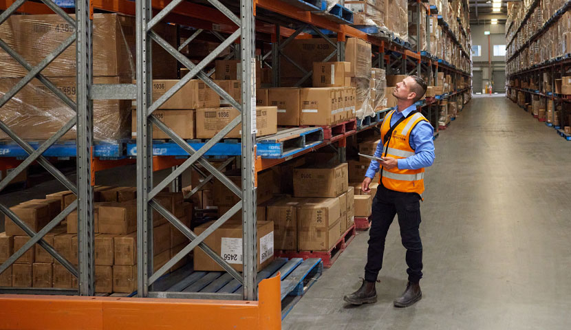 A working in high vis working in a warehouse.
