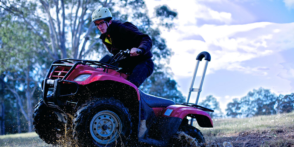 Farmer on a quad bike fitted with a roll bar