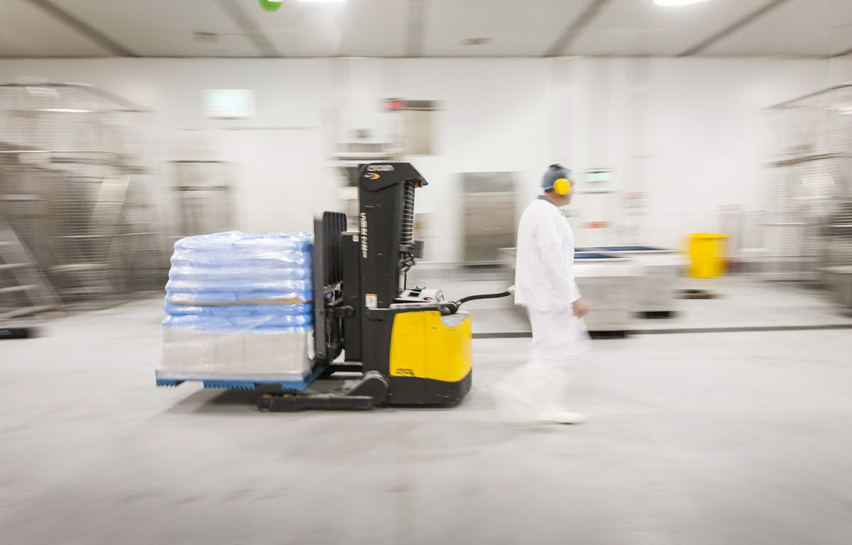 Worker operating an electric forklift in a warehouse