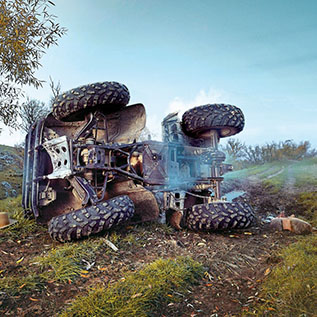 A quad bike that has rolled over onto its side and shows signs of damage.