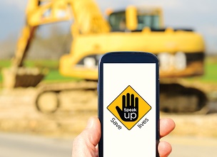 Image of a hand holding a mobile phone on a construction site