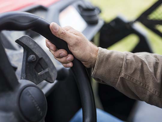 A hand holding a steering wheel
