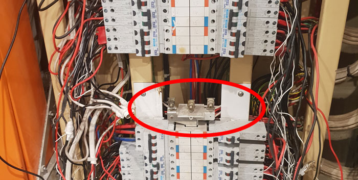 A switchboard with a live conductor highlighted with a red circle
