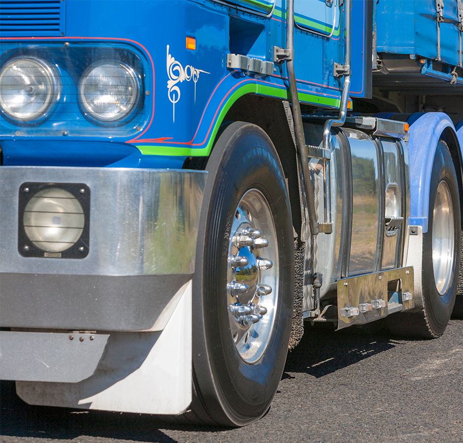 A close up of a blue Kenworth cab over truck 