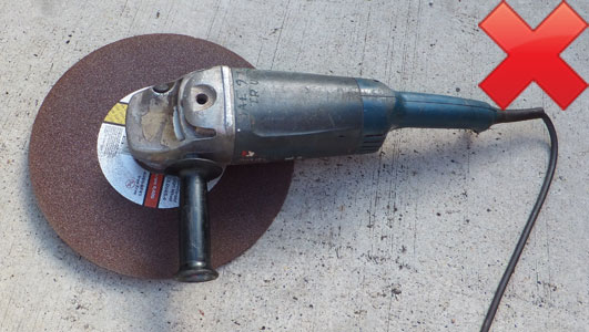 Unsafe 230 mm (9 inch) angle grinder with 356 mm (14 inch) disc fitted and guard removed